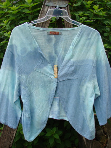 Barclay Gauze Open Front Shrug Mottled Sky Size 1 featuring a lightweight cotton gauze with three-quarter sleeves and unique triangular panels, displayed outdoors with a clothespin on a line.