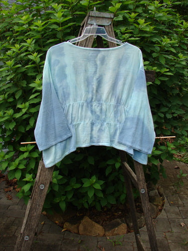 Barclay Gauze Open Front Shrug Mottled Sky Size 1 displayed on a wooden ladder, showcasing its open front, reverse triangular panels, and varying hemline, exemplifying BlueFishFinder's unique vintage style.