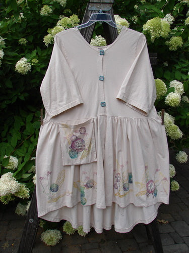 Barclay Flower Garden Cardigan Dress Dragonfly Natural Size 2 displayed on a swinger, showcasing a floral design, pleated skirt, and ceramic button front with an open lower front.