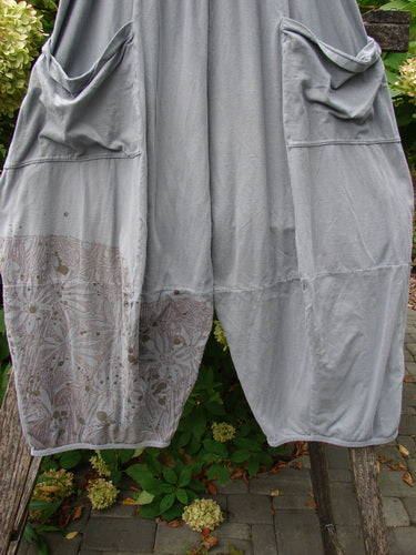 Barclay Crop Two Pocket 4 Square Pant Spin Flower Grey Green Size 0 displayed on a bench, showcasing dropped-crotch style, front patch pockets, and printed panel. Made from medium-weight organic cotton, highlighting unique design features.