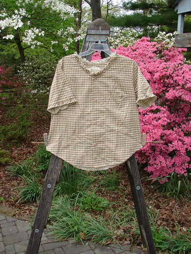 1996 Woven Boardwalk Top Unpainted Gingham White Pine Size 2 displayed on a stand, showcasing its gathered ruffle neck, sleeve lines, rounded hem, and bust line darts, made from woven organic cotton.