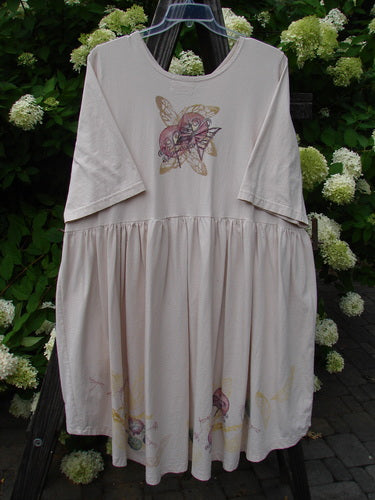 Barclay Flower Garden Cardigan Dress Dragonfly Natural Size 2, featuring a medium-weight organic cotton, ceramic button front, pleated skirt, and painted dragonfly theme, displayed on a rack.