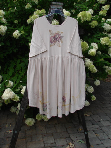 Barclay Flower Garden Cardigan Dress with dragonfly theme, featuring a three-button front, pleated skirt, and external pocket, hanging on a rack.