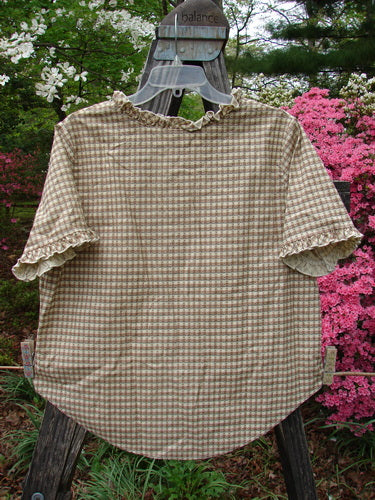1996 Woven Boardwalk Top Unpainted Gingham White Pine Size 2 on a hanger; features gathered ruffle neck and sleeve lines, rounded hem, bust darts, and wider shape, made from woven organic cotton.