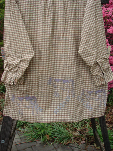 1996 Woven Tourist Top Farm Cow White Pine Gingham OSFA: Long-sleeved, lightweight cotton shirt with tiny wooden buttons, vented sides, and farm cow border theme, displayed on a clothes rack.