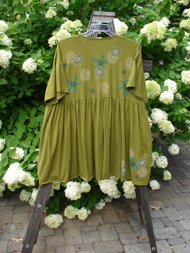 Barclay Tree Top Cardigan Dress Floral Blossom Olive Size 3 displayed on a wooden swing, featuring vintage buttons, V-neckline, empire waist, and gathered lower skirt, showcasing a peasant-style look.