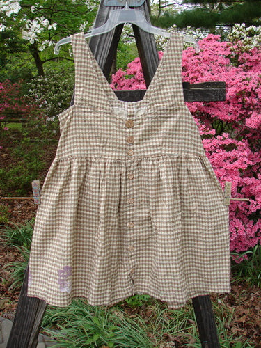 1996 Woven Roadside Jumper Flower Wheel White Pine Gingham Size 1 displayed on a clothesline, showing wooden buttons, a pleated blousy lower, squared neckline, and flower wheel design, emphasizing its vintage charm and organic cotton fabric.