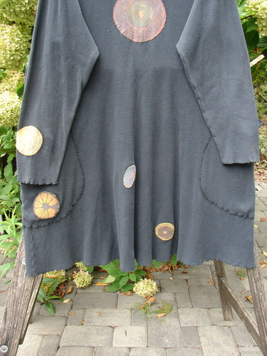 Barclay Patched Thermal Exterior Stitch Side Pocket Tunic Off Black Size 2, featuring curly edged turtleneck, warm-toned appliqués, and generous pockets with exterior stitching, hanging outdoors.