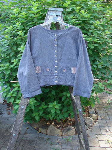 Barclay Hemp Cotton Cayman Shirt in Blue Denim features a circular floral pattern and distinct A-line flair, showcased on a garden swing, embodying Bluefishfinder.com's unique vintage style.