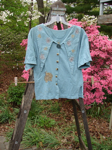 1994 Compass Top Garden Bee Dusk Size 1 displayed outdoors on a wooden ladder, featuring a unique pointed collar, original buttons, side vents, and a detailed garden bee theme.