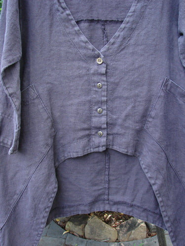 Close-up of the Barclay Hemp Cotton Summercloth Dip Side Pocket Jacket Pinwheel Brum Size 1, showcasing its deep V-neckline, three-quarter sleeves, tiny front buttons, and dual angular pockets with pinwheel theme paint.