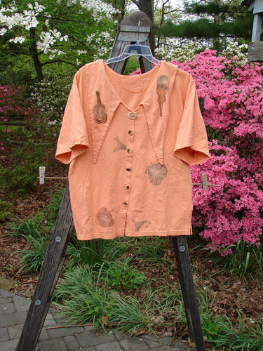 1994 Compass Top Beach Shell Music Reef Size 2, displayed on a hanger, featuring an exaggerated elongated collar, original vintage buttons, side vents, and mixed theme paint with music and sea life designs.