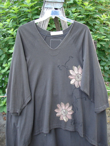 1998 Botanicals Bell Flower Top CXLVIII Raven Size 2 features a flower-themed design on a grey shirt, highlighting a scooped hem, rounded neckline, and sectional panels, embodying vintage Blue Fish Clothing's creative style.