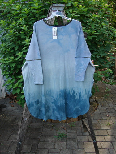 Barclay NWT Thermal Contrast Revival Top Love Dove Blue Skies OSFA displayed on a clear plastic hanger, showcasing its ribbed neckline and sleeves, with unique side vents and a rounded A-line shape.