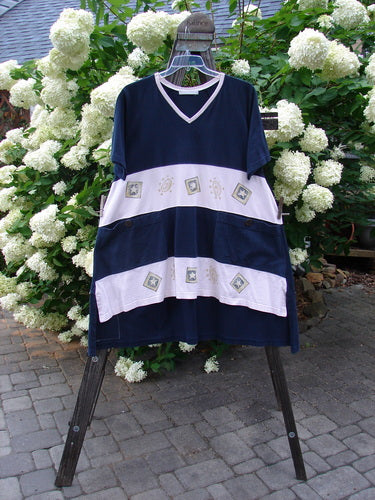1998 Cricket Top Star Game Crew Blue Size 2 displayed on a swing, showcasing its A-line shape, ribbed V-neckline, front pockets with numeral buttons, and unique hemline.