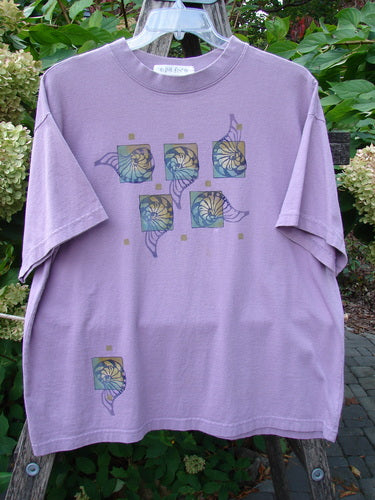 1997 Short Sleeved Tee Five Shell Jasmine Size 1: Lavender T-shirt with floral motif panels, hanging outdoors. Features a thicker ribbed neckline, straight boxy shape, and signature Blue Fish patch.