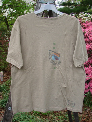2000 Artist Choice Short Sleeved Tee Geo Dove Size 1 displayed on a wooden clothes rack, showcasing its mid-weight organic cotton fabric, drop shoulders, and simplistic geometric theme paint.