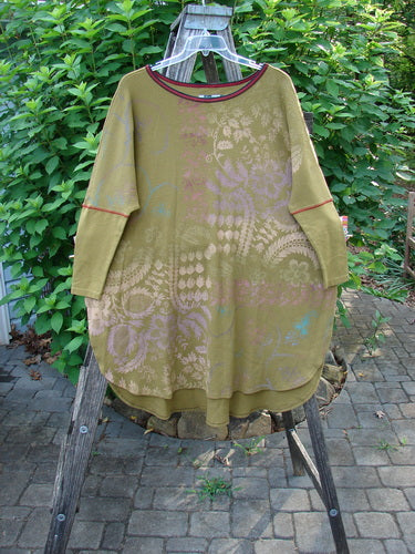 Barclay Thermal Contrast Revival Top Botanicals Yellow Olive OSFA displayed on a wooden stand, showcasing its rounded ribbed neckline and tapering ribbed sleeves, highlighting the continuous botanical theme.