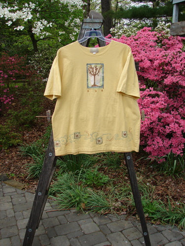 2000 Artist Choice Short Sleeved Tee Tree Key Lime Pie Size 1 on a hanger, showcasing its slightly thinner rolled neckline, drop shoulders, and longer generous shape with tree theme paint.