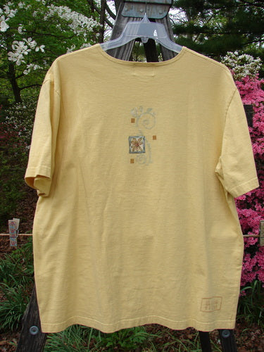2000 Artist Choice Short Sleeved Tee Tree Key Lime Pie Size 1 displayed on a clothes rack, showcasing a unique tree design, rolled and ribbed neckline, drop shoulders, and a longer, generous shape.