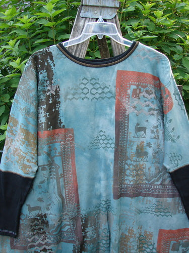 Barclay Thermal Contrast Revival Top Farm Turq OSFA displayed on a clear plastic hanger, featuring a unique farm-themed pattern with contrasting ribbed sleeves and a rounded neckline, set against a wooden surface.