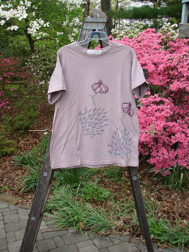1998 Botanicals Short Sleeved Tee Echinacea Passiflora Size 0 displayed on a wooden ladder, featuring colorful floral designs and a thick ribbed neckline, highlighting the shirt's vintage charm and artistic detail.