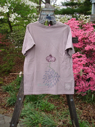 1998 Botanicals Short Sleeved Tee Echinacea Passiflora Size 0 displayed on a wooden hanger, featuring colorful botanical prints and a thicker ribbed neckline, reflecting vintage Blue Fish Clothing's creative essence.