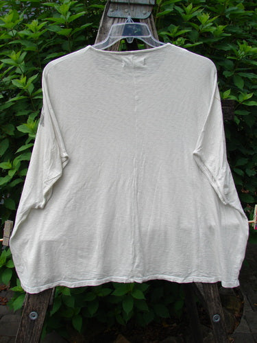 Barclay Cotton Slub Cricket Cap Sleeve Tee in Stone Blossom Creme on a hanger, showcasing its seamless shoulder sleeves, slightly flared hip, and rounded hem, reflecting BlueFishFinder's vintage, expressive style.