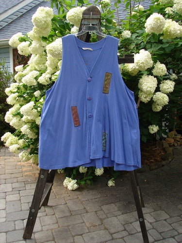 1997 Simple Vest Flower Sprig Skylark Size 2: Swingy blue vest with deep side pockets, oversized knotted buttons, and a sweet flower sprig patch on the lower back.