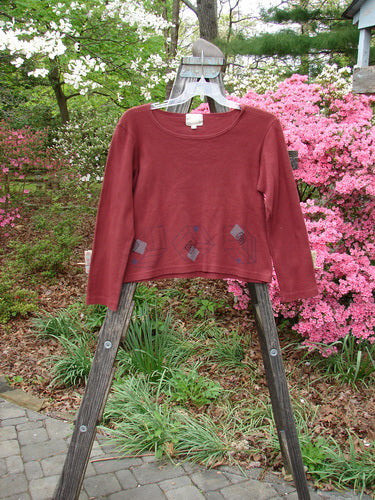 1999 Round Neck Rib Top Cubist Woodberry Size 1 displayed on a wooden rack, showcasing its unique knit ribbed material and slightly flared hemline, embodying vintage fashion from Bluefishfinder.com.