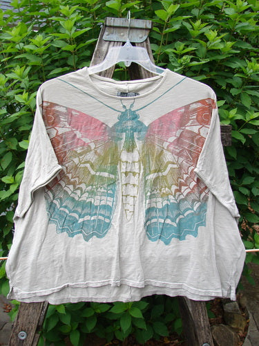 Barclay Cotton Slub Cricket Cap Sleeve Tee Butterfly Flax OSFA features an organic cotton design with butterfly garden paint, seamless cap sleeves, and a boxy shape, reflecting BlueFishFinder's vintage style.