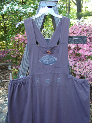 1995 Omega Jumper Magic Leaf Bloomsberry OSFA on a wooden rack, featuring a wider front bib, stoneware buttoned front pocket, sectional panels, and apron-style look with replaced elastic sides.