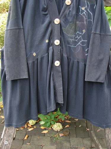 Barclay Thermal Bungalow Jacket Modern Graphics Black OSFA features a deep V-neck, large wooden buttons, and an abstract graphic design, draped over a bench, emphasizing its unique flair and versatility.