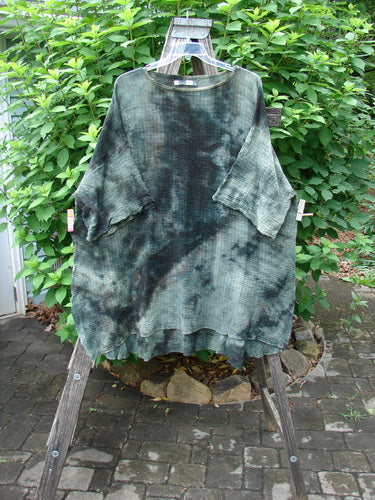 Barclay Crinkle Gauze Ana Tunic Dress Unpainted Mottled Forest OSFA on a clothes rack, showcasing its wide three-quarter sleeves, seamless shoulders, and varying hemline, capturing the vintage Blue Fish Clothing essence.