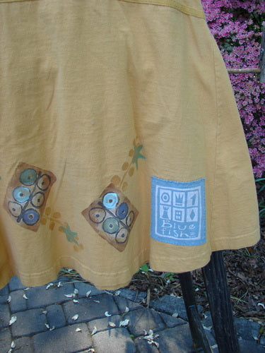 1998 Baseball Dress Games Lemonade Size 0: A yellow skirt with blue designs, featuring a deep V-neckline, dark buttons, paneled breast pocket, drop waist seam, and A-line lower sweep.