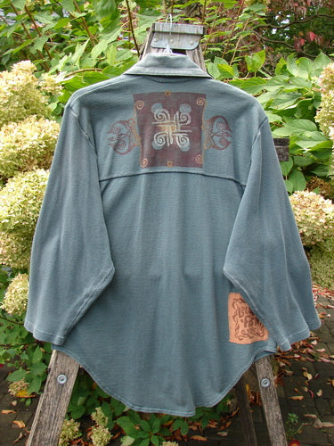 1996 Celtic Filias Jacket Celtic Loch Size 1 draped over ladder, showcasing Celtic motifs on the back with Roam Free label. Features drop shoulders, oversized pockets, and shiny diamond-cut buttons.