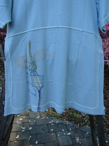 1998 Botanicals Snapdragon Top Birdsong Size 1: Blue shirt featuring a dragonfly design, slightly flared shape, rounded neckline, tall vented sides with button, full exterior stitchery, and no pockets.