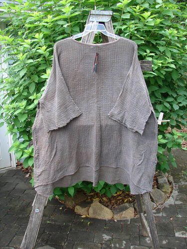 Barclay NWT Crinkle Gauze Ana Tunic Dress in Mottled Latte, displayed on a clothes rack, features a shallow neckline, wide three-quarter sleeves, and varying hemline, embodying Bluefishfinder.com's vintage, creative style.