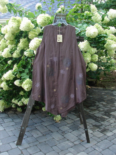 1998 NWT Hemp Silk Sanjo Vest in Boxwood on a wooden rack, showcasing a sleeveless, A-line design with wooden buttons, varying hemline, and signature Blue Fish patch.