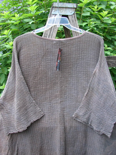 Barclay NWT Crinkle Gauze Ana Tunic Dress Unpainted Mottled Latte OSFA displayed on a wooden stand, showcasing its wide three-quarter sleeves, shallow neckline, and varying hemline, exemplifying BlueFishFinder's vintage style.