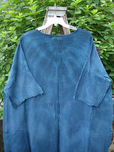 Barclay NWT Crinkle Gauze Ana Tunic Dress in Mottled Teal displayed on a wooden swing. Features include a shallow neckline, wide sleeves, and varying hemline, embodying BlueFishFinder's vintage style.