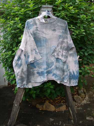 Barclay NWT Crinkle Gauze Top Mottled Pink Gray Celestial OSFA displayed on a wooden ladder, showcasing its high-low hemline and three-quarter dolman sleeves, embodying BlueFishFinder's vintage creative style.