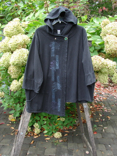 Barclay Fleece Single Button Hooded Jacket Grid Black Size 2 draped over a wooden ladder, featuring wide sleeves, patch pockets, and a large button. The jacket showcases a grid pattern in a garden setting.