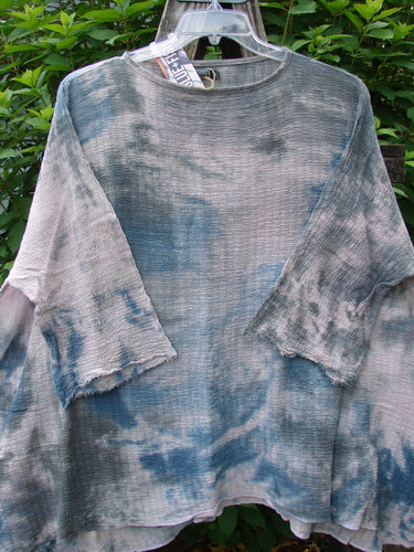 Barclay NWT Crinkle Gauze Top Mottled Pink Gray Celestial OSFA displayed on a hanger, showcasing its wide, boxy silhouette, three-quarter dolman sleeves, and unique high-low hemline.