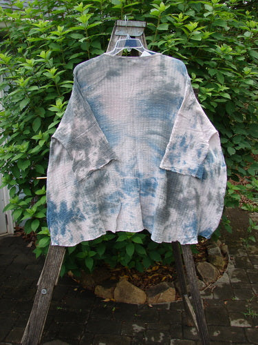 Barclay NWT Crinkle Gauze Top Mottled Pink Gray Celestial OSFA displayed on a hanger, showcasing its high-low hemline, wide boxy shape, and dolman sleeves with a frayed edge.