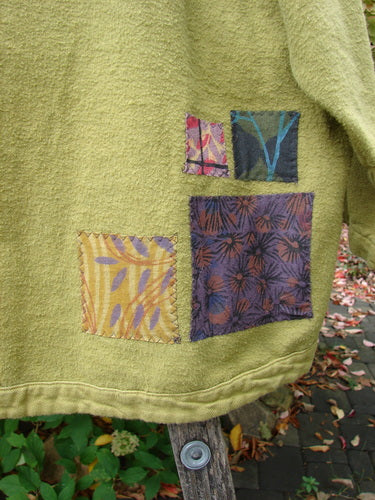 Barclay Patched Flannel Frolic Jacket Green Seed Size 2 draped on a wooden chair, showcasing textured fabric with unique patches and a cozy, wide hemline, embodying BlueFishFinder's creative and vintage aesthetic.