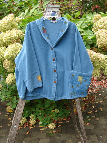 Barclay Patched Flannel Frolic Jacket Garden Blue Teal Size 2 features a button-front design, notched collar, drop shoulders, oversized pocket with subtle print, and ribbed corded outer, draped over a wooden ladder.