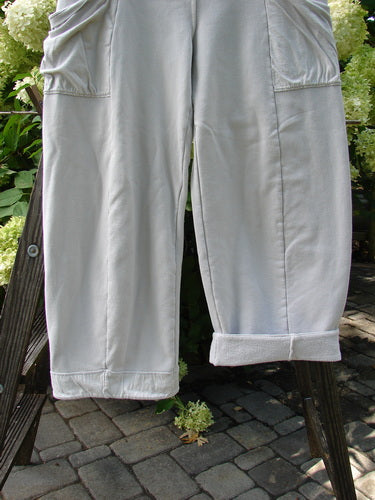 Barclay Interlock Cuff Toboggan Reversible Pant Unpainted Pebble Size 1, hanging on a clothesline, showcasing fleece-cuffed lowers and oversized side pockets, emphasizing its unique reversible design and cozy fabric.