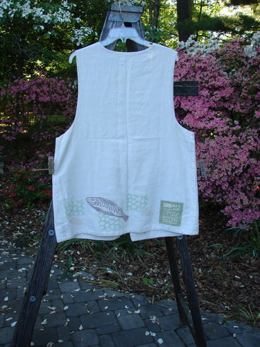 1999 Textured Linen 2 Pocket Vest Fish Natural Size 0 displayed on a wooden rack, showcasing its A-line shape, deep arm openings, oversized front pockets, and pearl buttons.