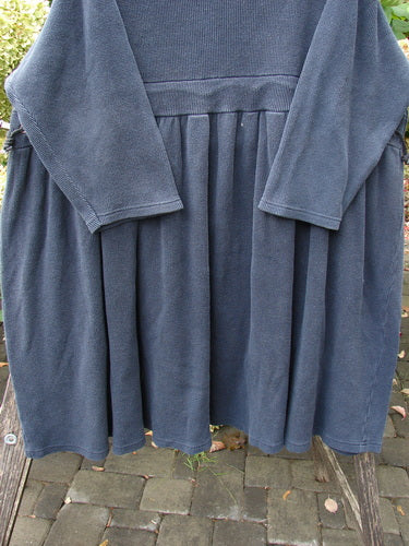 1992 Thermal Circus Dress Unpainted Black Size 2 displayed draped over a wooden bench. Features include a gathered skirt, wide neckline, and empire waist cord, embodying Bluefishfinder.com's vintage aesthetic.